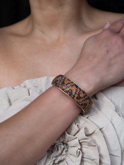 80DB Roaring Rhythm cuff with animal-inspired dark brown and black crystal stones in a wavy design