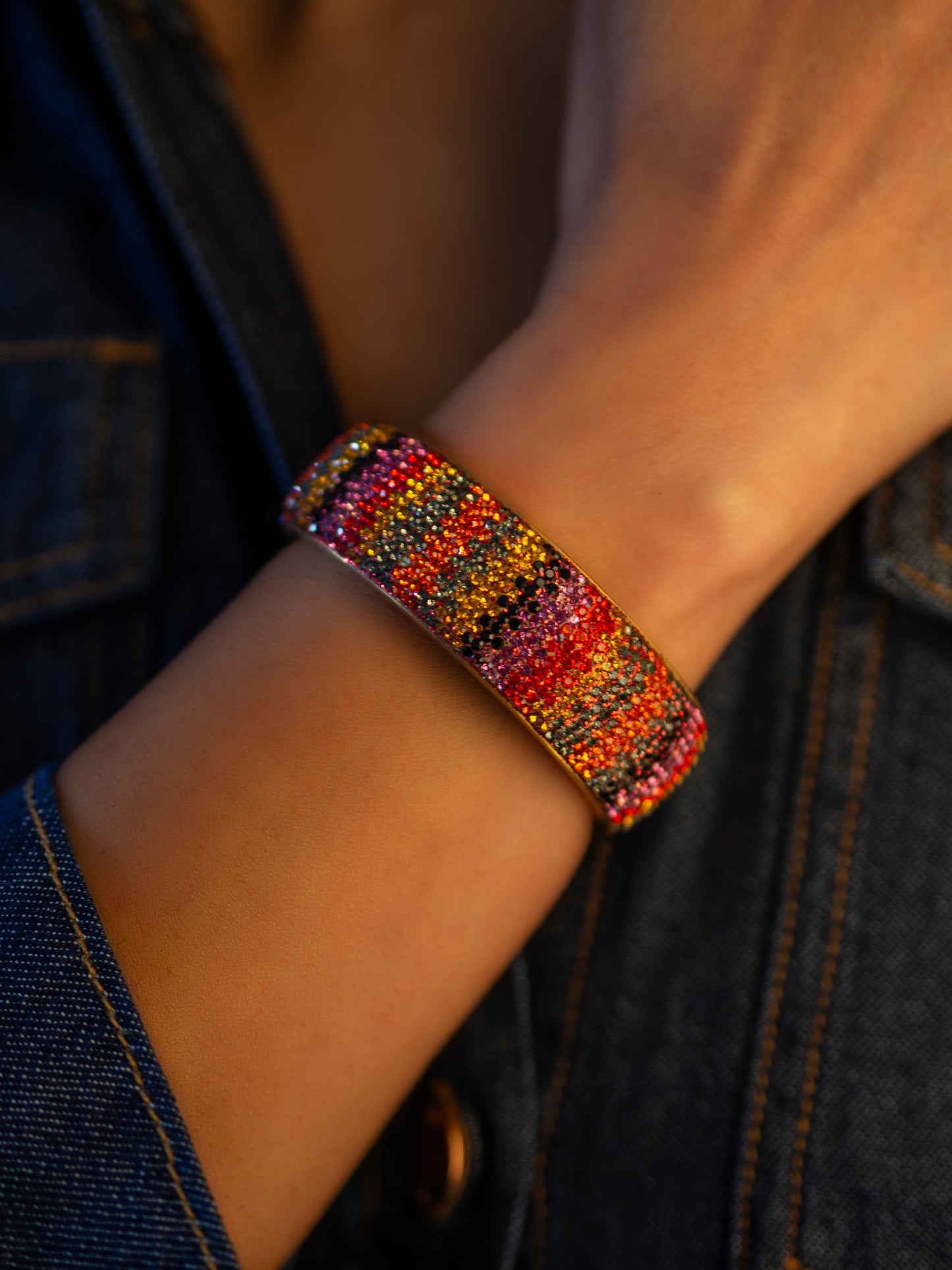 80DB Spectrum Symphony cuff featuring a vibrant multi-coloured crystal pattern that creates a bold visual symphony of red, yellow and striking hues